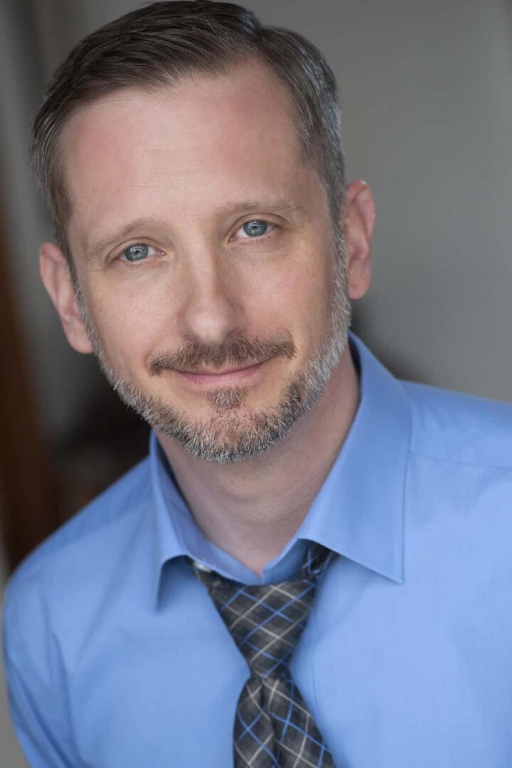 A man with a beard and blue shirt